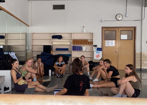 Dancers sitting in a circle on the first day of class