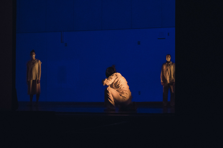 Dancers performing behind open garage doors on a loading dock