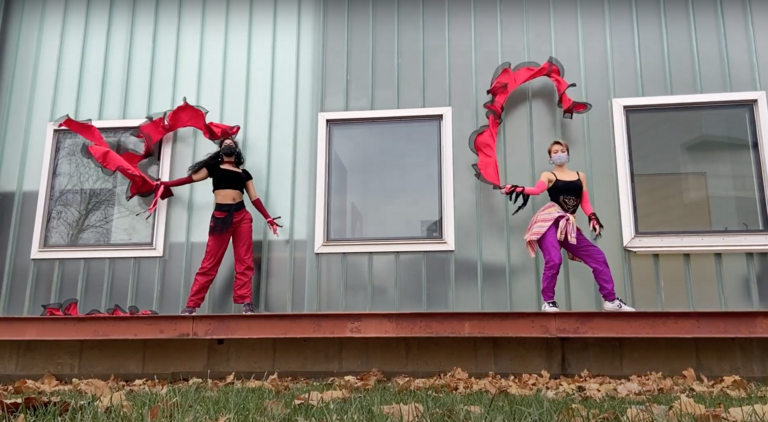 Two dancers waving red fabric