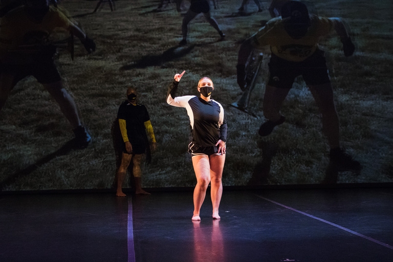 Dancer making an "I" shape with their hand