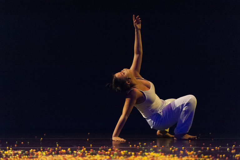 Dancer on stage, dancing on what appears to be Skittles