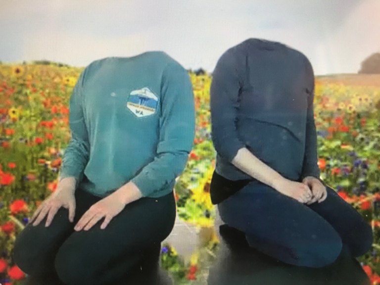 Two dancers kneeling in a green screen meadow without heads