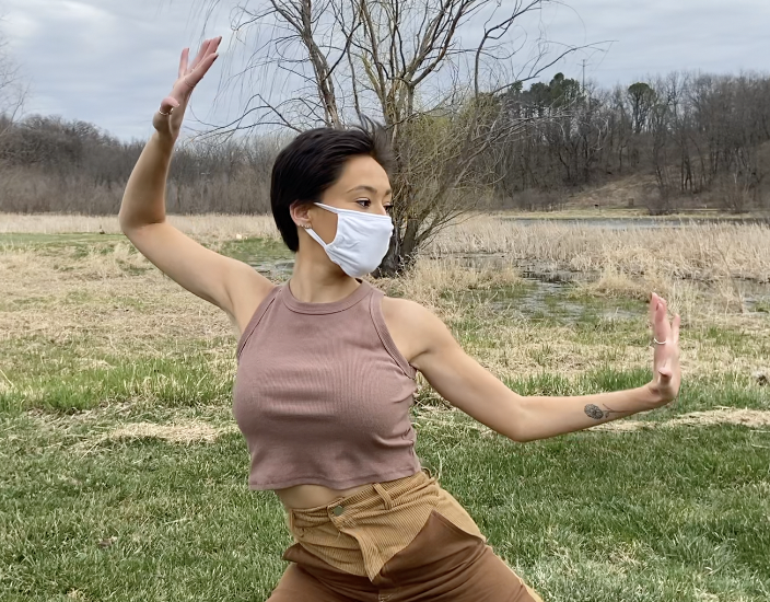 Dancer in a mask performing in a grassy field