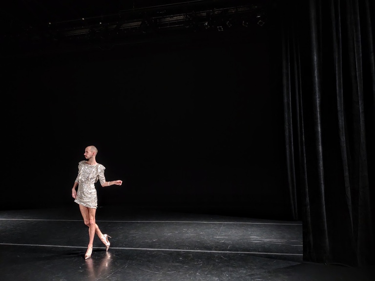 Sean Thomas Boyt dancing on stage in a sequin dress.