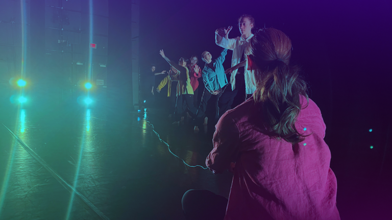 Seven dancers in performance on stage.