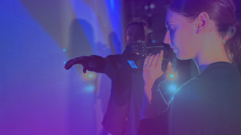 Photo of video camera getting a close up shot of a dancer's hand.