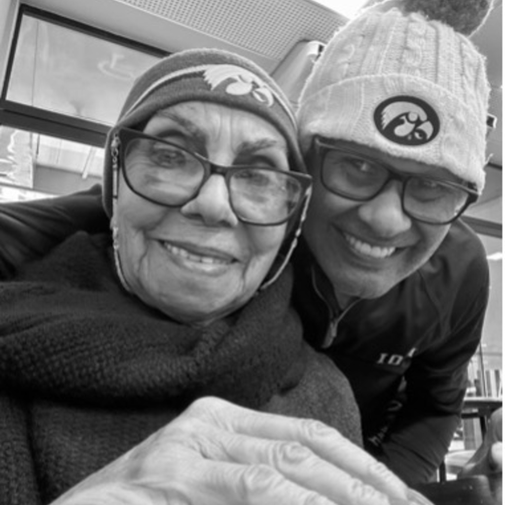 Armando Duarte smiling with his mom, hugging her from behind