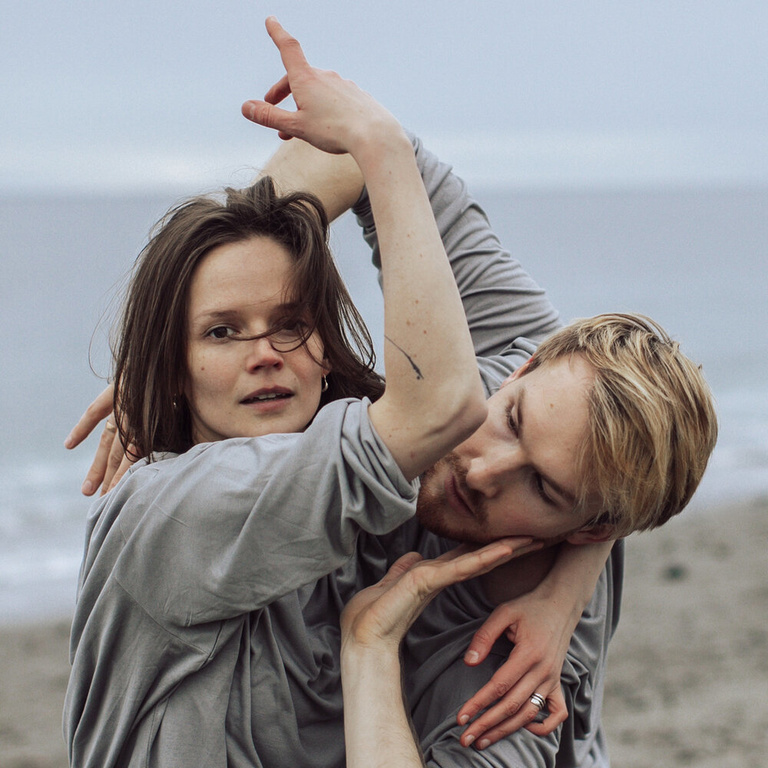 two dancers intertwined on the beach