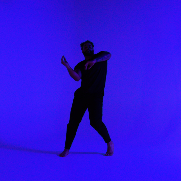 Lovar Davis Kidd dancing in front of a blue background