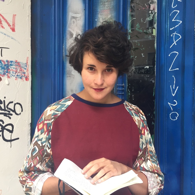 Lénaïg Cariou looking at camera smiling holding a book