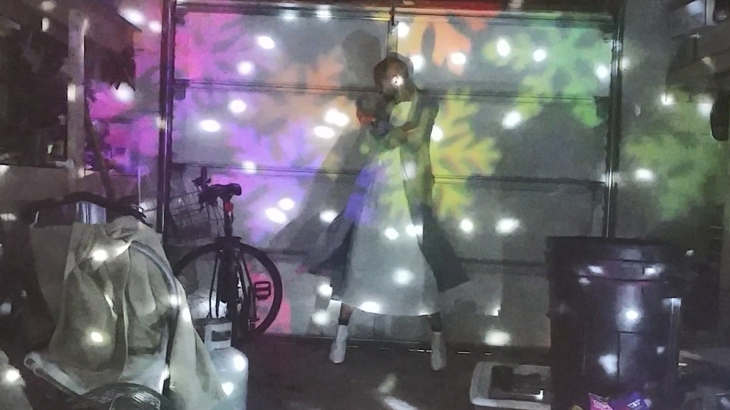 Dancer in garage with Christmas lights projected on them