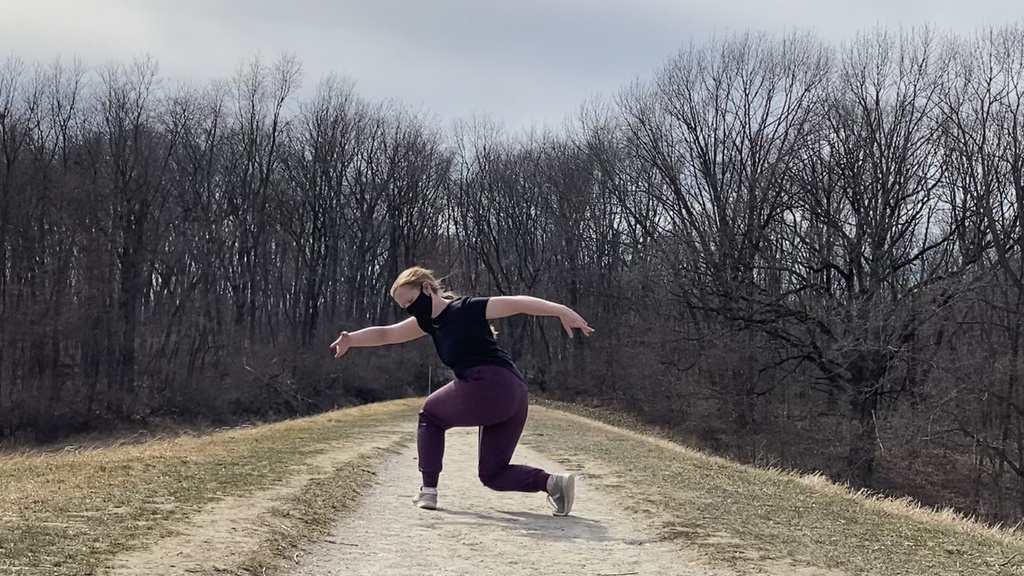 Dancer performing on outdoor trail.