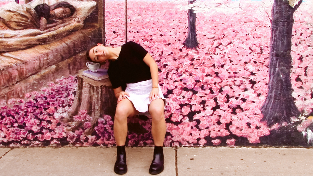 Isabella Buscaglia in front of a mural of flowers
