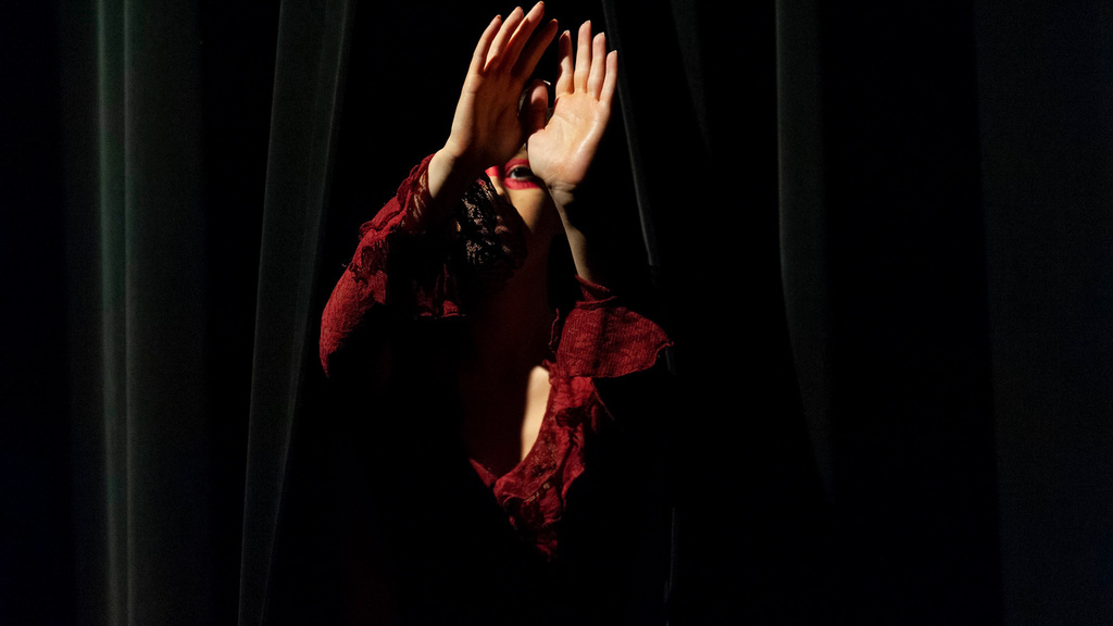 Dancer in red peaking between the curtains