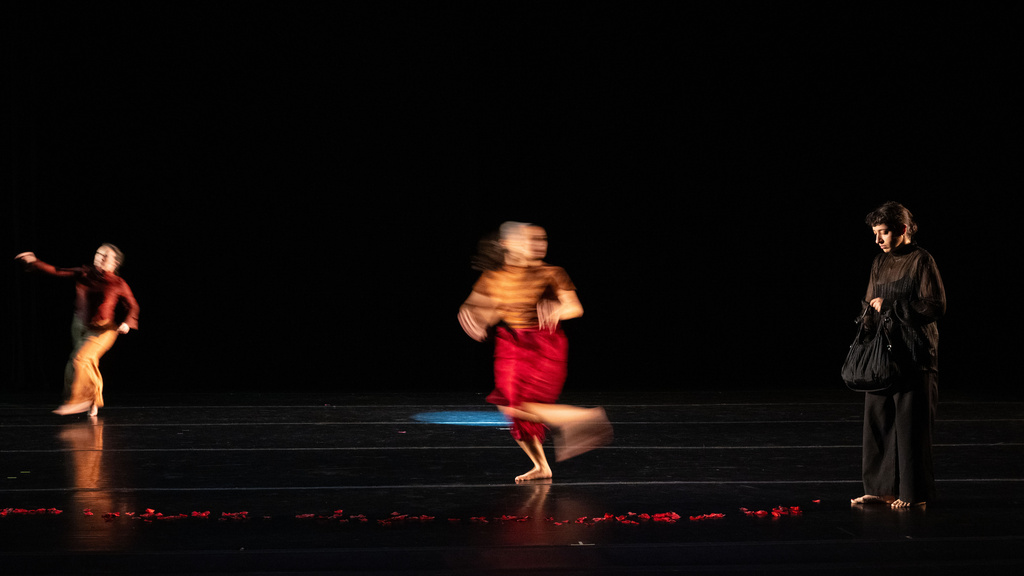 Blurred dancers on stage in a dark theater