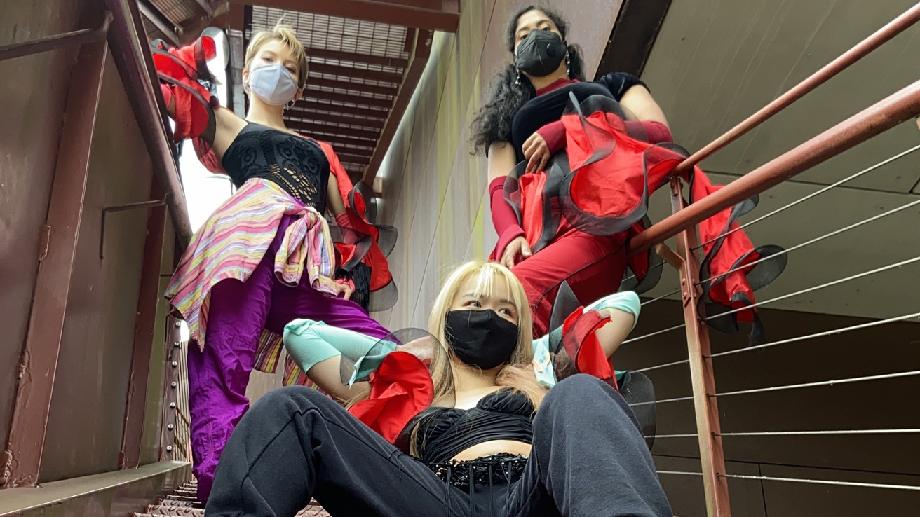 Dancers posing on stairs in masks