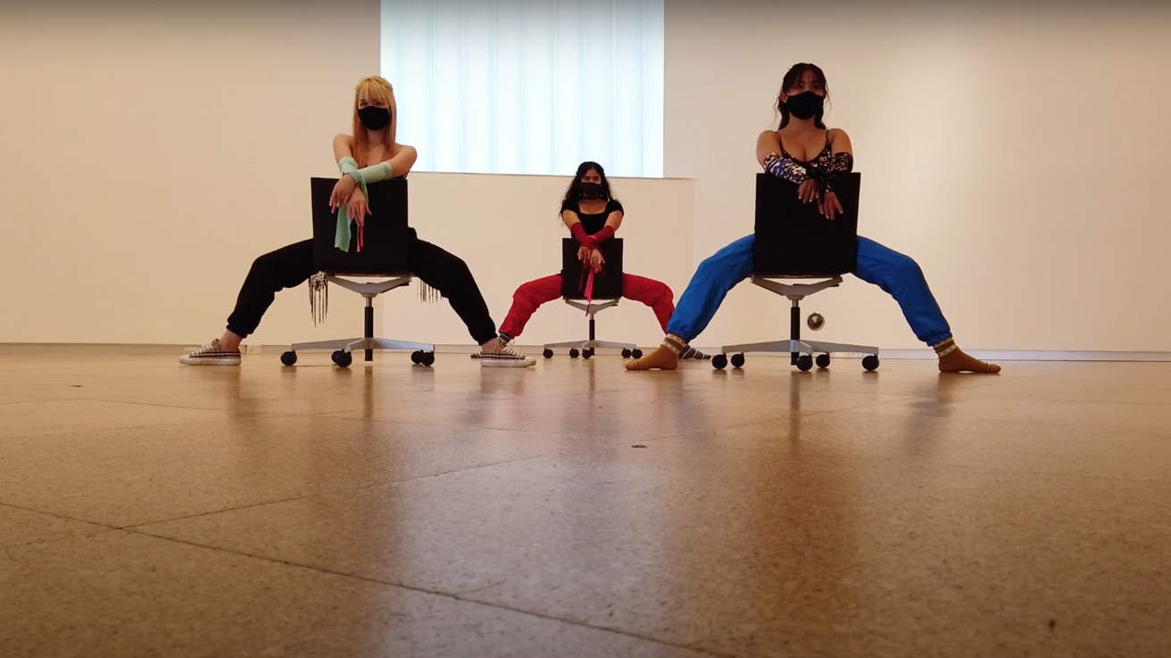 Dancers sitting on chairs backwards
