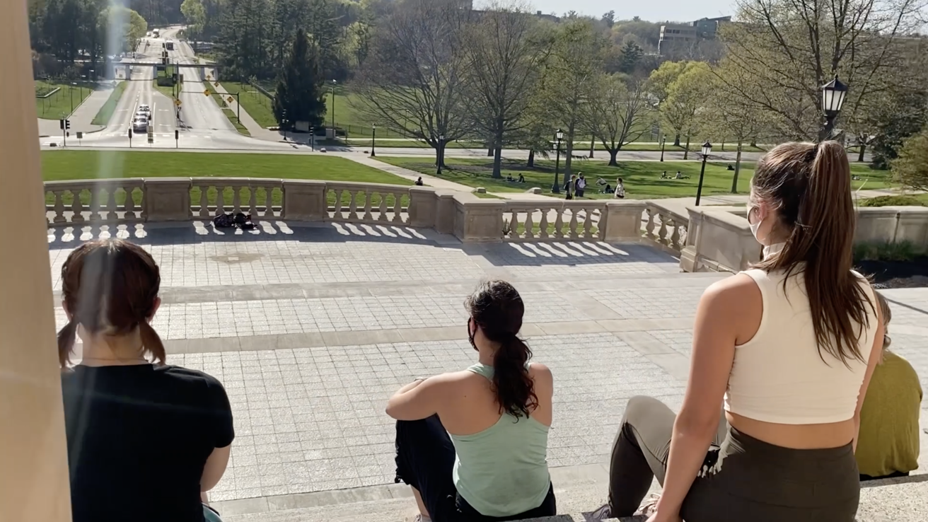 Dancers sitting on steps of Old Capitol.